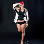 Amputee woman standing with red painted hand